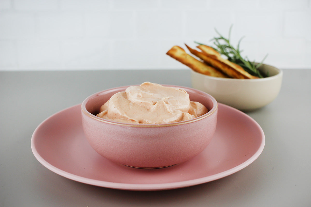 Schale mit cremigem Dip, daneben Schälchen mit Fladenbrot und Rosmarinzweig